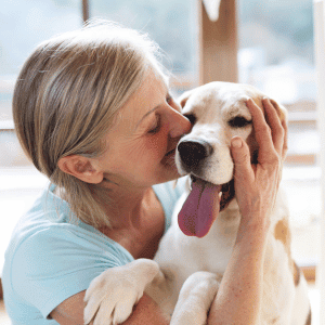 woman with dog in embrace - CT Shoreline - How Dogs Enhance Our Health and Happiness