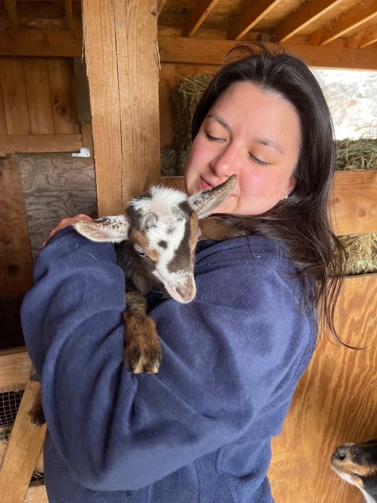 Adriana hugging a lamb